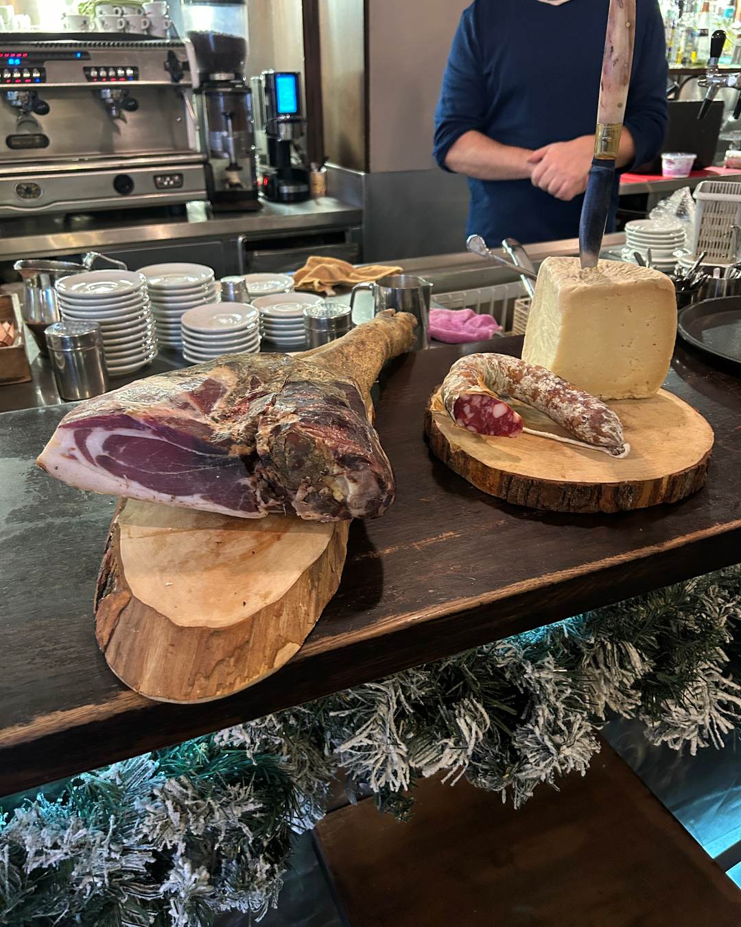 Il bancone con il prosciutto sardo e la forma di formaggio